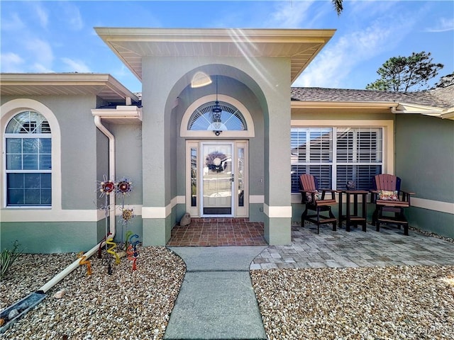 doorway to property featuring stucco siding