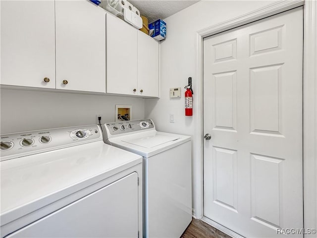 laundry room with dark wood-type flooring, washer and dryer, and cabinet space