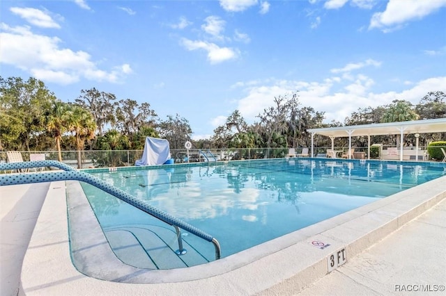 community pool with a water slide and fence