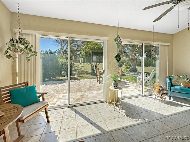 doorway to outside with tile patterned flooring, a ceiling fan, and a wealth of natural light