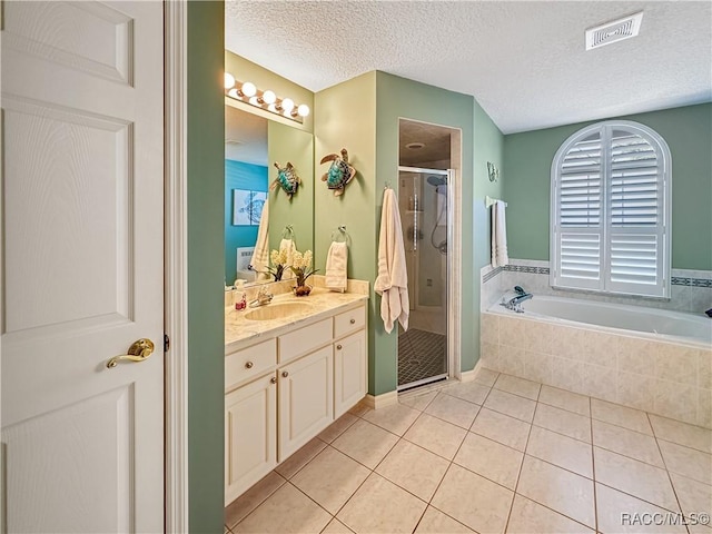 bathroom featuring tile patterned floors, visible vents, a stall shower, vanity, and a bath