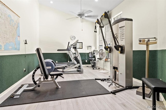 exercise area with wood finished floors, a ceiling fan, and baseboards