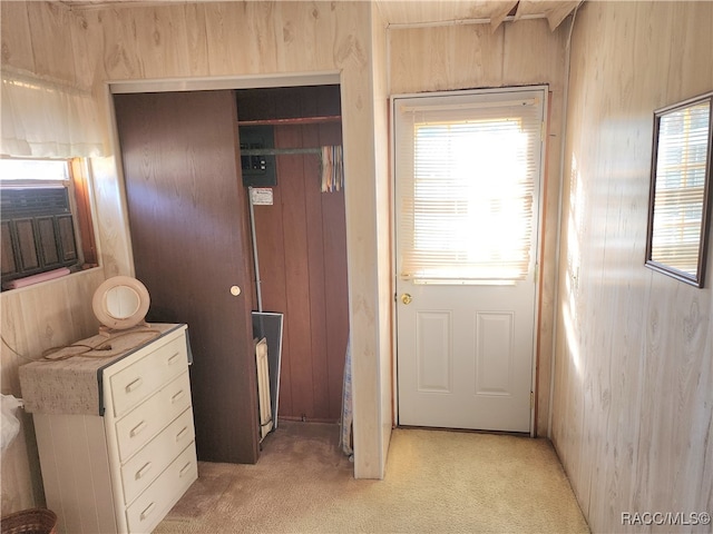 interior space featuring light carpet and wood walls