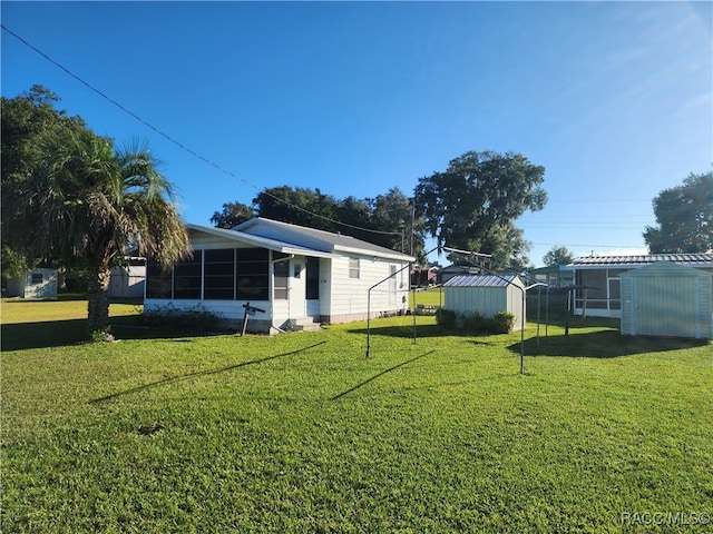 view of yard featuring a sunroom and a shed