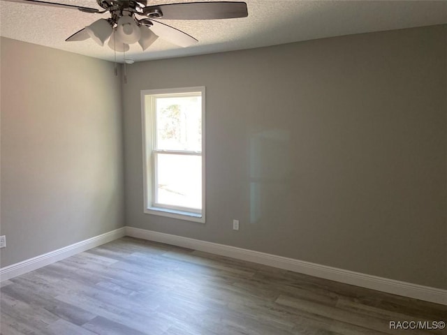 empty room featuring hardwood / wood-style flooring, ceiling fan, and a textured ceiling