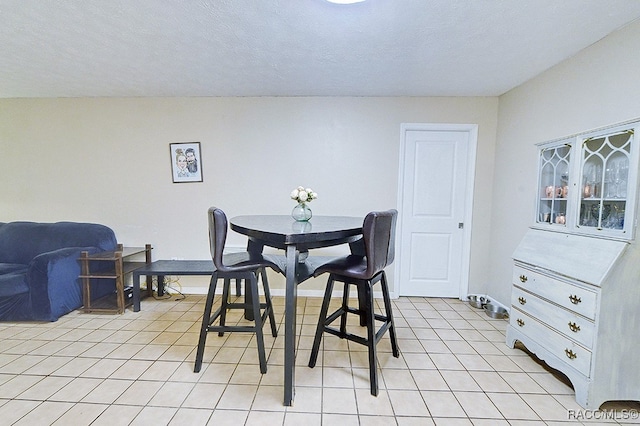 dining room with light tile patterned floors and a textured ceiling