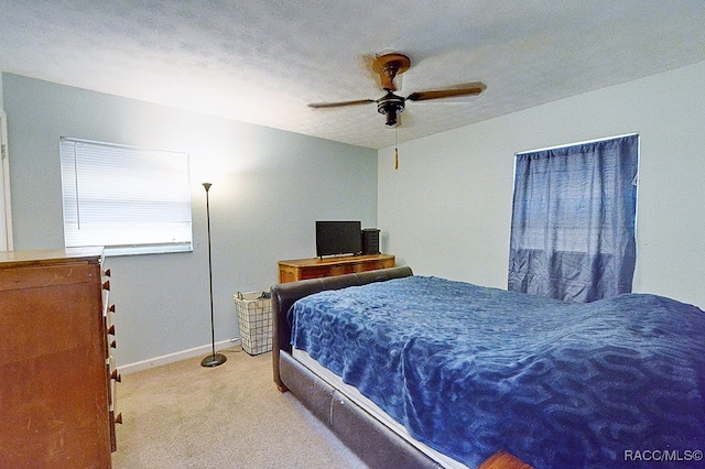 bedroom with light carpet, a textured ceiling, and ceiling fan