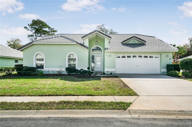 view of front of home with a garage, a tile roof, and stucco siding