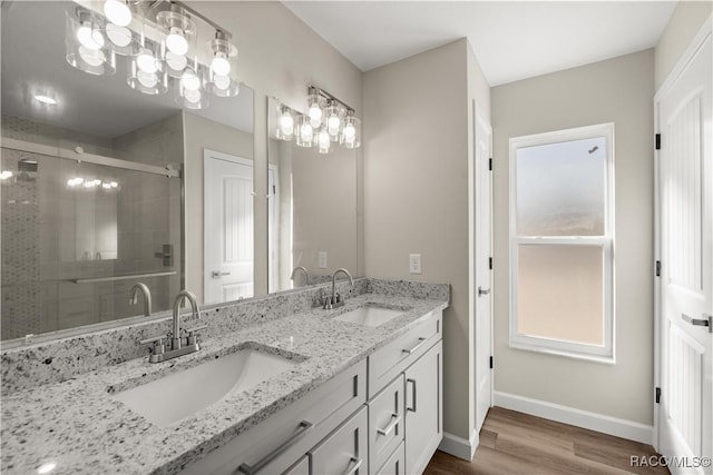 bathroom with wood-type flooring, vanity, and walk in shower