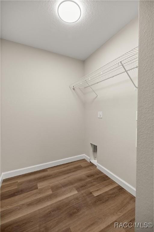 laundry room with hookup for an electric dryer, hardwood / wood-style floors, and a textured ceiling