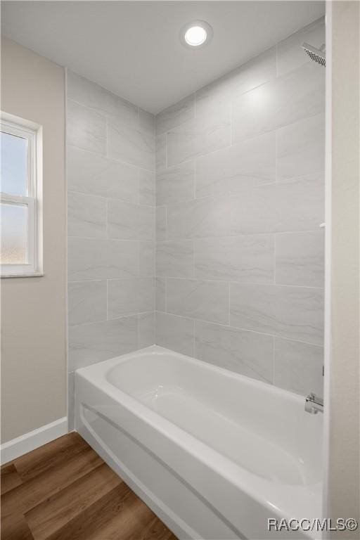 bathroom with shower / bathing tub combination and hardwood / wood-style flooring