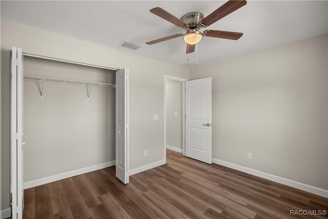 unfurnished bedroom featuring dark wood-type flooring, ceiling fan, and a closet