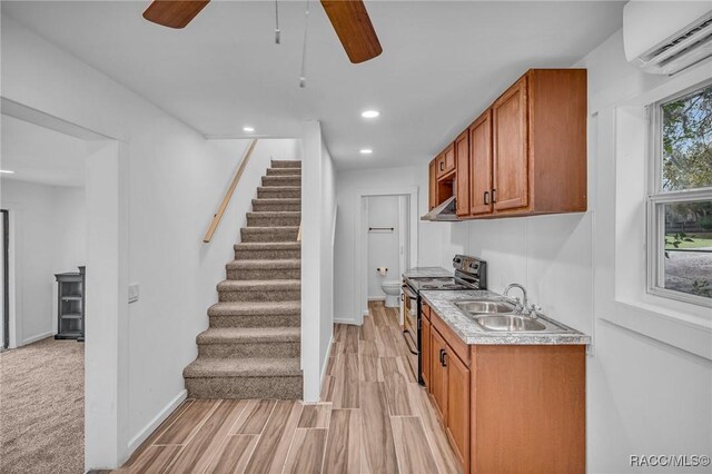 19190 SE 136th Ct, Dunnellon, FL 34431 - kitchen featuring brown cabinets, a wall unit AC, electric range, a sink, and under cabinet range hood