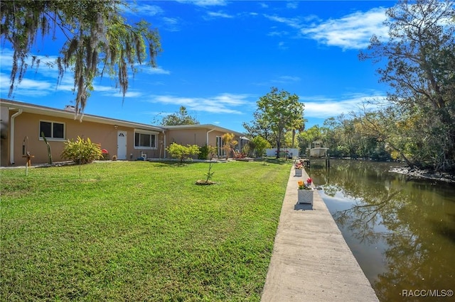 view of dock featuring a water view and a yard