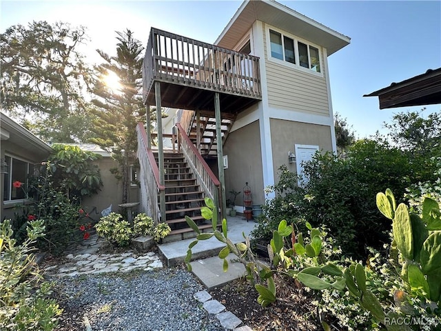 1203 SE Kings Bay Dr, Crystal River, FL 34429 - rear view of house with stairway, a wooden deck, and stucco siding
