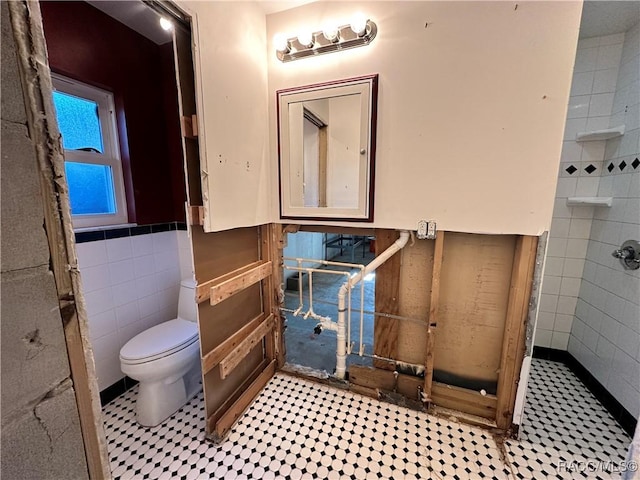 1203 SE Kings Bay Dr, Crystal River, FL 34429 - bathroom featuring a tile shower, toilet, and tile walls
