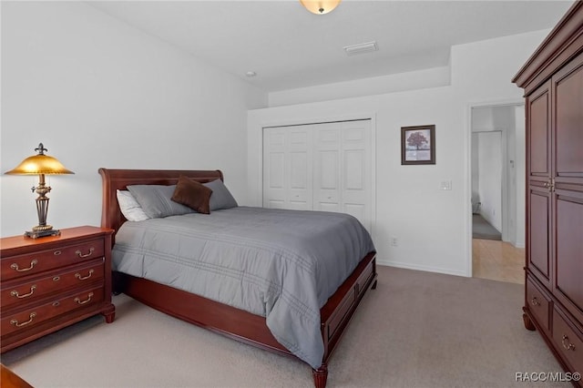 bedroom with baseboards, visible vents, a closet, and light colored carpet