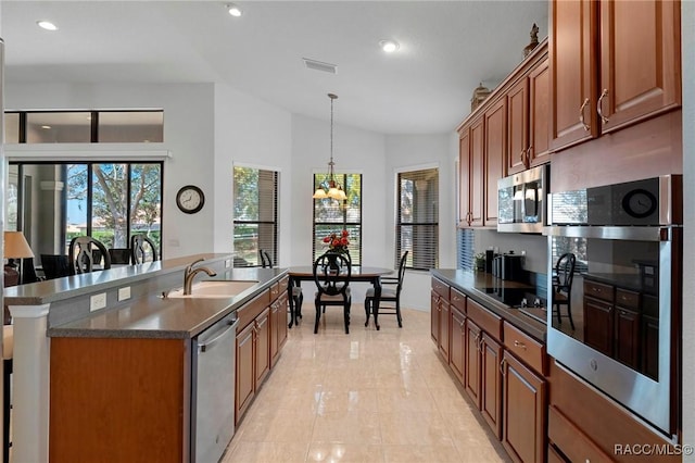 kitchen featuring lofted ceiling, a sink, visible vents, appliances with stainless steel finishes, and dark countertops