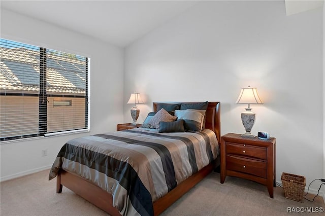 bedroom featuring lofted ceiling and carpet