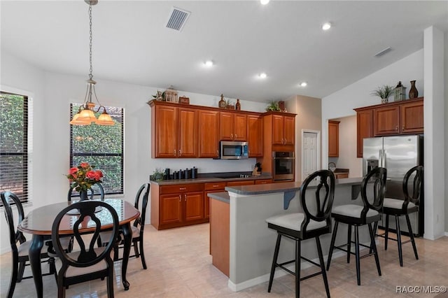 kitchen with appliances with stainless steel finishes, brown cabinetry, and visible vents