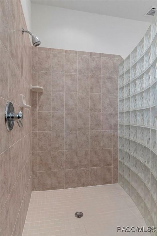 bathroom featuring visible vents and tiled shower