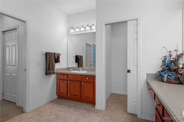 bathroom with tile patterned floors, baseboards, and vanity