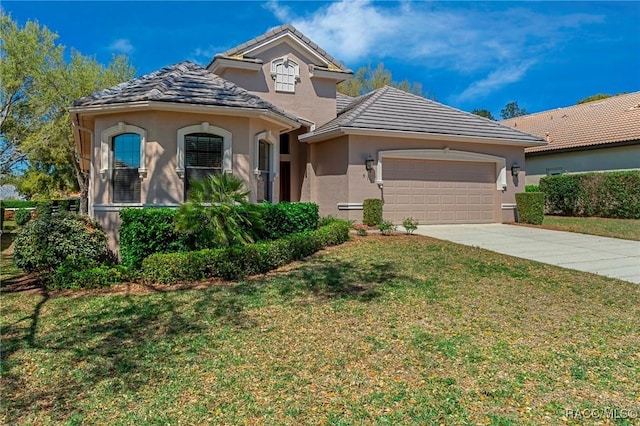 mediterranean / spanish house featuring driveway, a garage, a tile roof, a front yard, and stucco siding