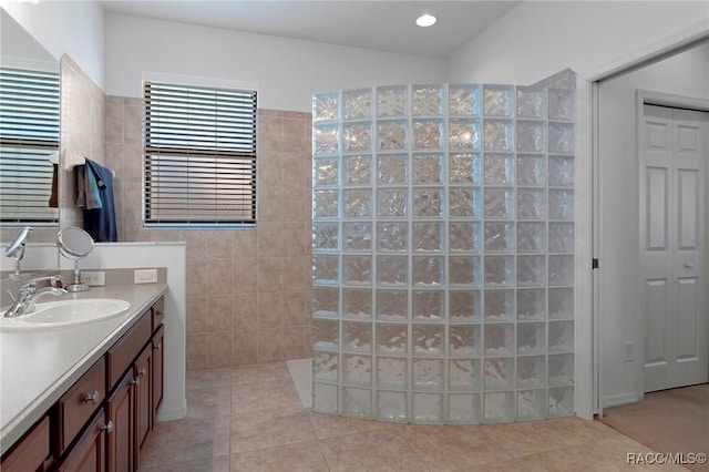 bathroom with a walk in shower, recessed lighting, tile walls, vanity, and tile patterned floors