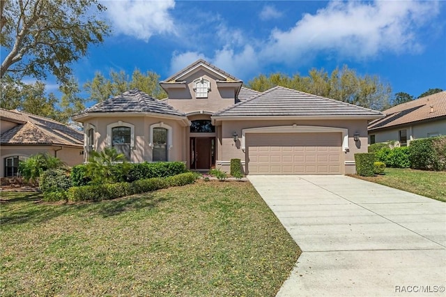 mediterranean / spanish-style home featuring concrete driveway, a tile roof, an attached garage, a front lawn, and stucco siding