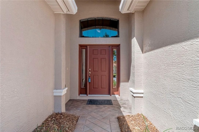 view of exterior entry featuring stucco siding