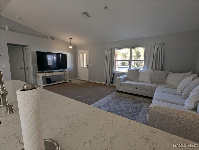 living room with dark colored carpet and vaulted ceiling