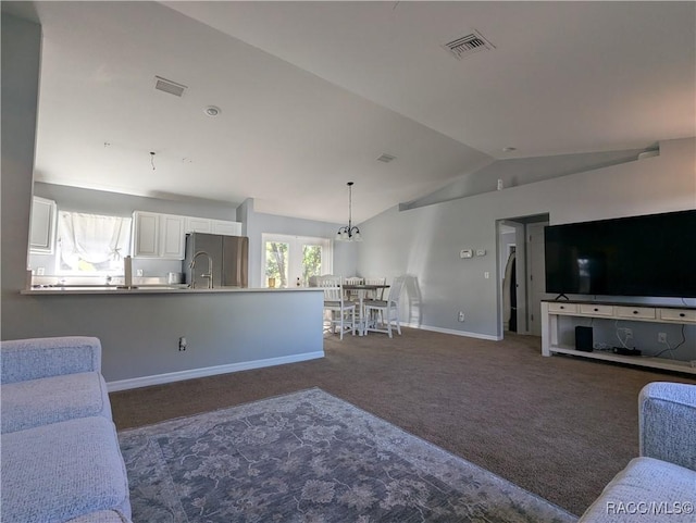 living room featuring vaulted ceiling, sink, and dark carpet