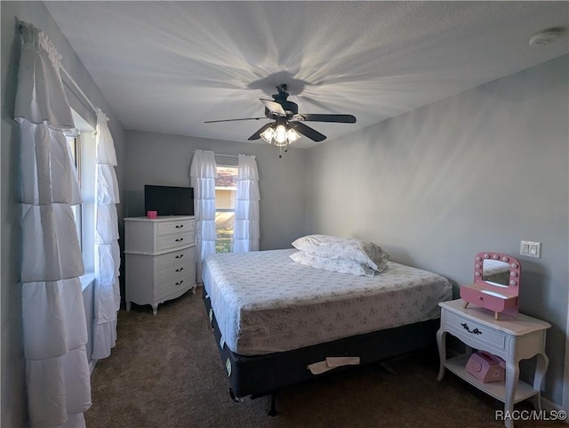 bedroom featuring ceiling fan and dark colored carpet