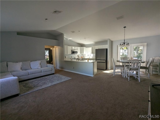 unfurnished living room with sink, vaulted ceiling, and carpet