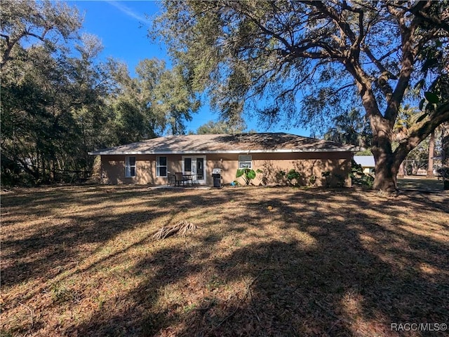 rear view of house featuring a yard