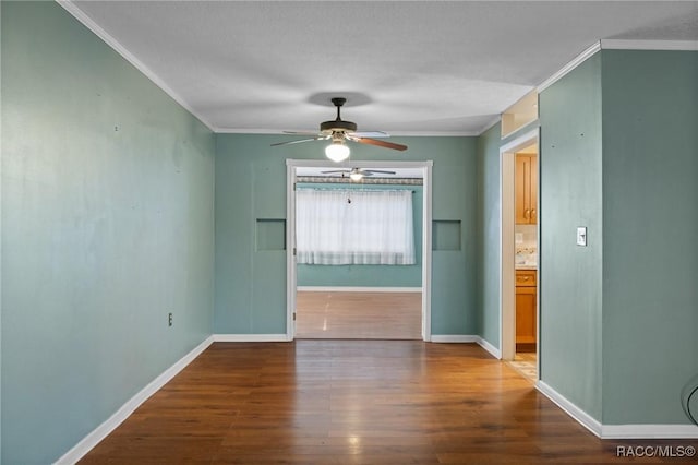 empty room featuring crown molding, hardwood / wood-style floors, and ceiling fan