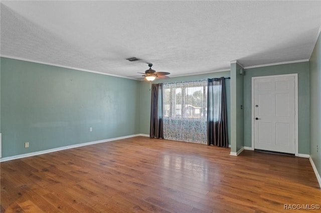 empty room with ornamental molding, hardwood / wood-style floors, ceiling fan, and a textured ceiling