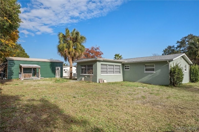 rear view of house featuring a lawn