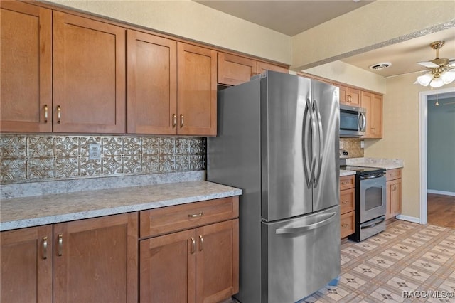 kitchen featuring decorative backsplash, ceiling fan, and appliances with stainless steel finishes