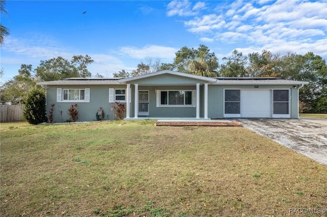 ranch-style home with a garage, a front lawn, solar panels, and a porch