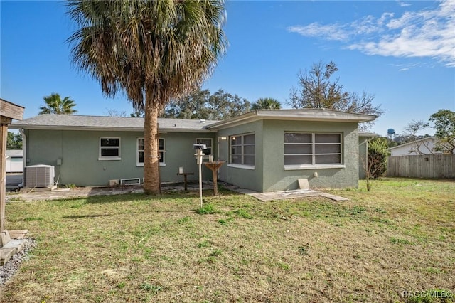 back of property featuring central AC and a lawn