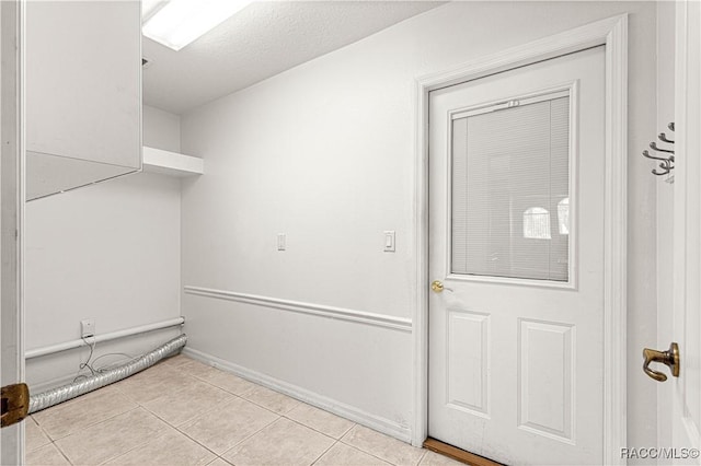 laundry area with a textured ceiling and tile patterned floors