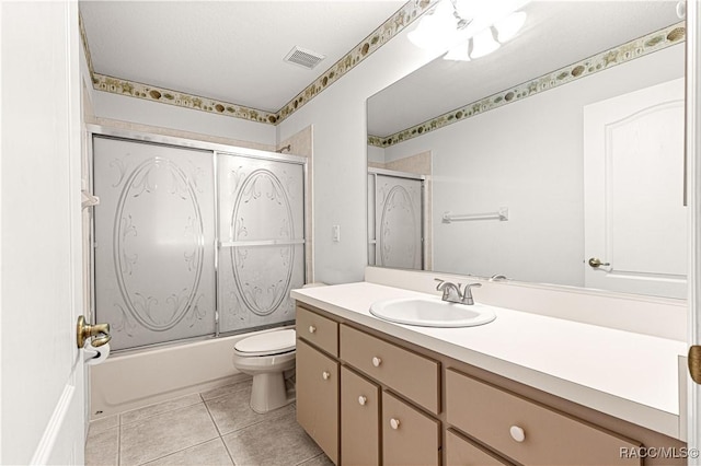 full bath featuring visible vents, toilet, tile patterned flooring, combined bath / shower with glass door, and vanity