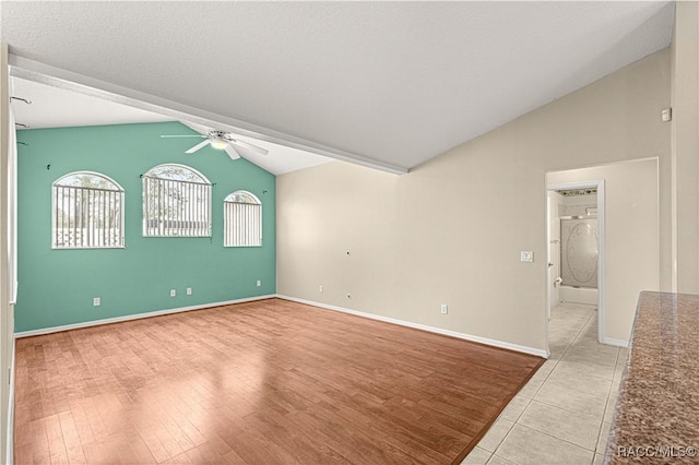 unfurnished room featuring lofted ceiling, light wood-type flooring, baseboards, and a ceiling fan