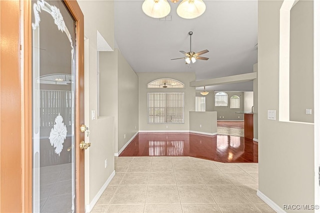 tiled entrance foyer with ceiling fan and baseboards