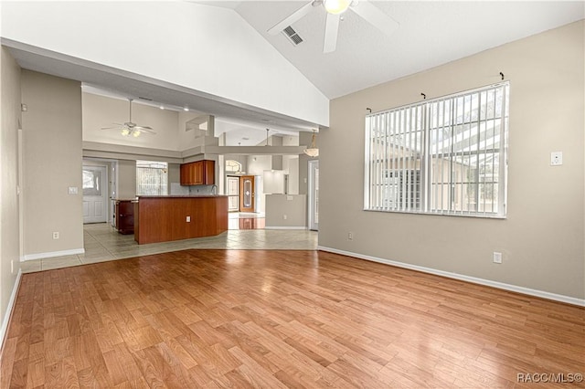 unfurnished living room featuring light wood-type flooring, ceiling fan, high vaulted ceiling, and baseboards