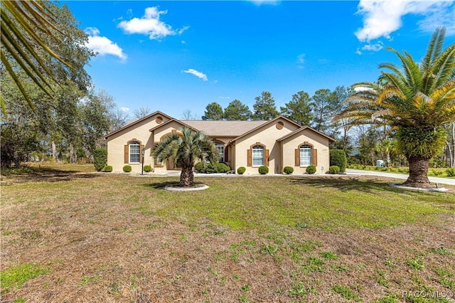 mediterranean / spanish home with a front yard and stucco siding