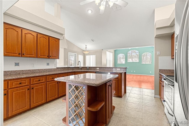 kitchen with brown cabinetry, a sink, a peninsula, and open shelves