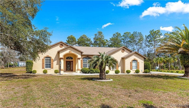 mediterranean / spanish-style home featuring a front lawn and stucco siding