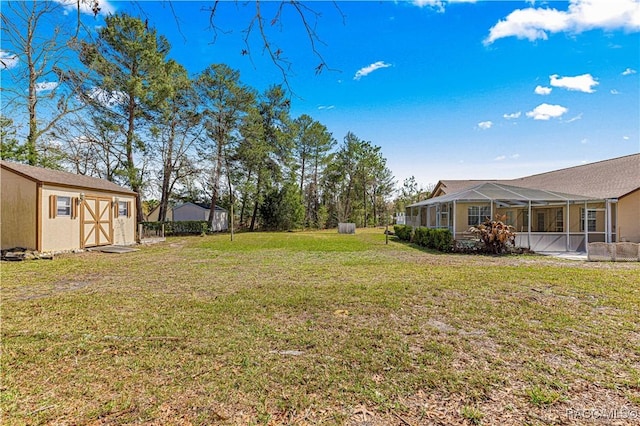 view of yard with a storage shed, an outdoor structure, and a lanai